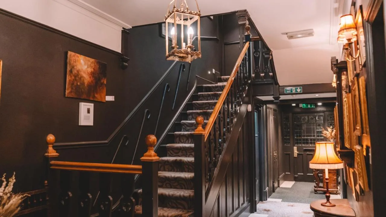 A staircase in a building with a black wall at The Galaxie in Oxford