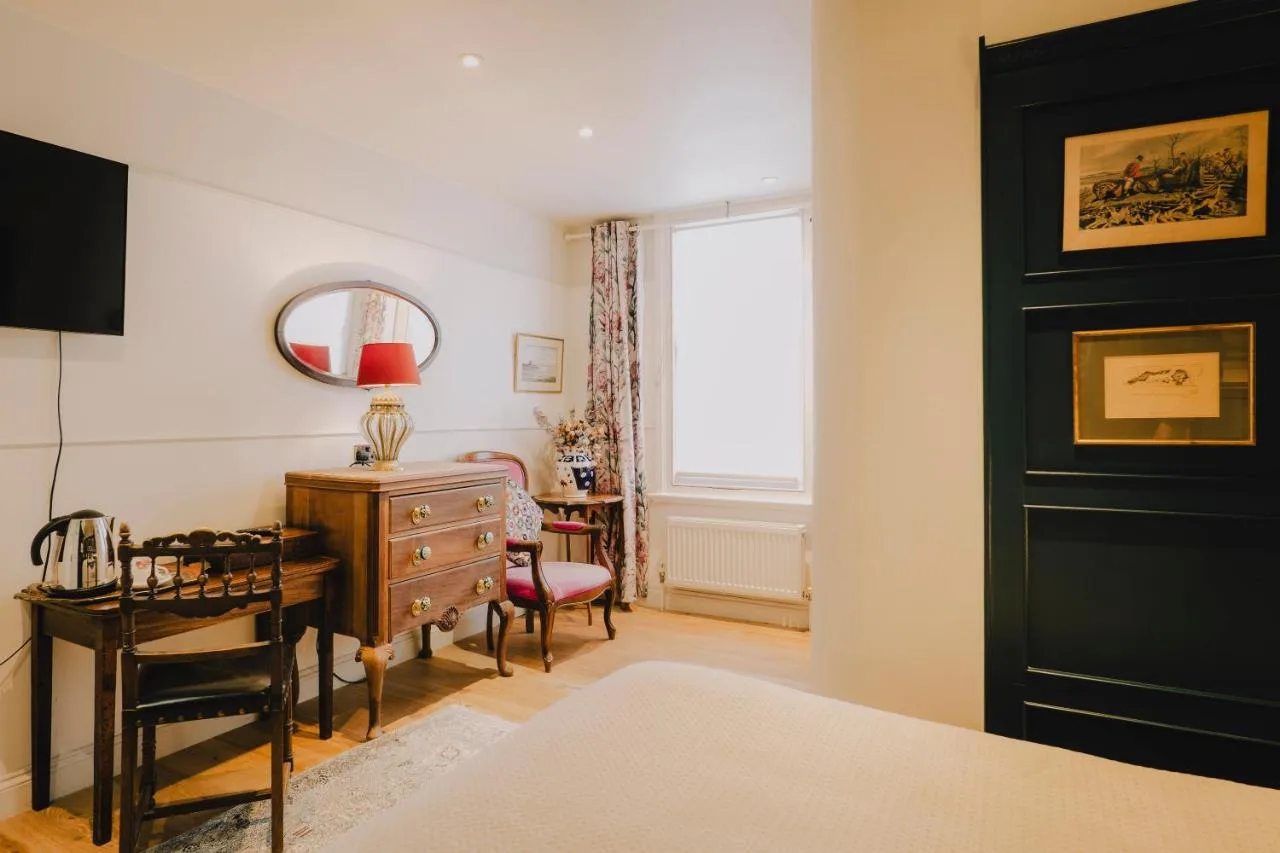 A bedroom with a desk and a table and a window at The Galaxie in Oxford