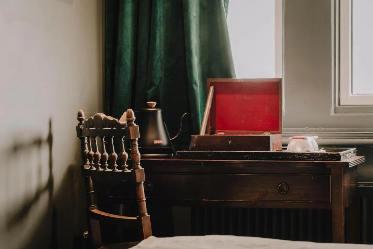 A wooden desk with a chair next to a window at The Galaxie in Oxford