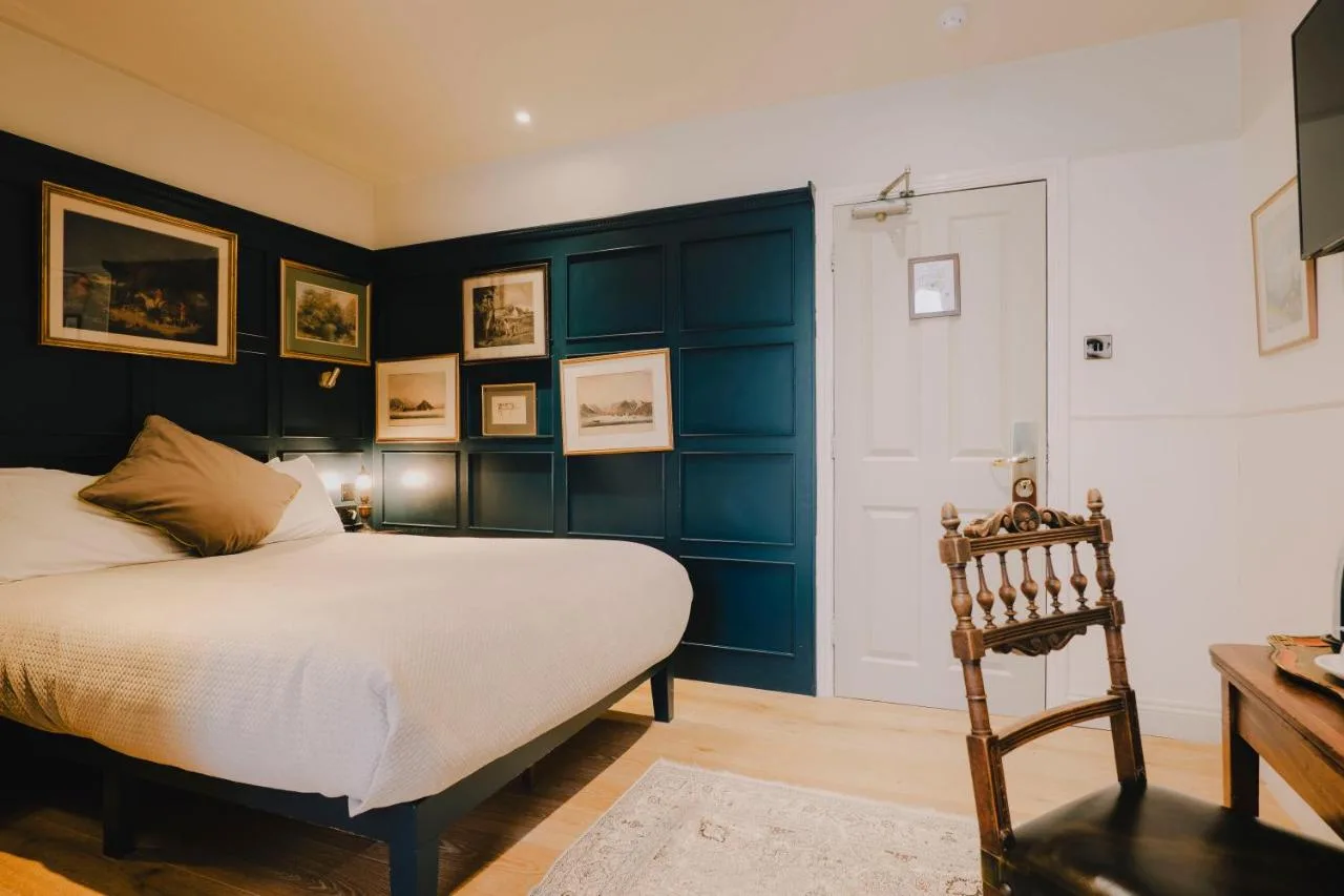 A bedroom with blue walls and a bed and a chair at The Galaxie in Oxford