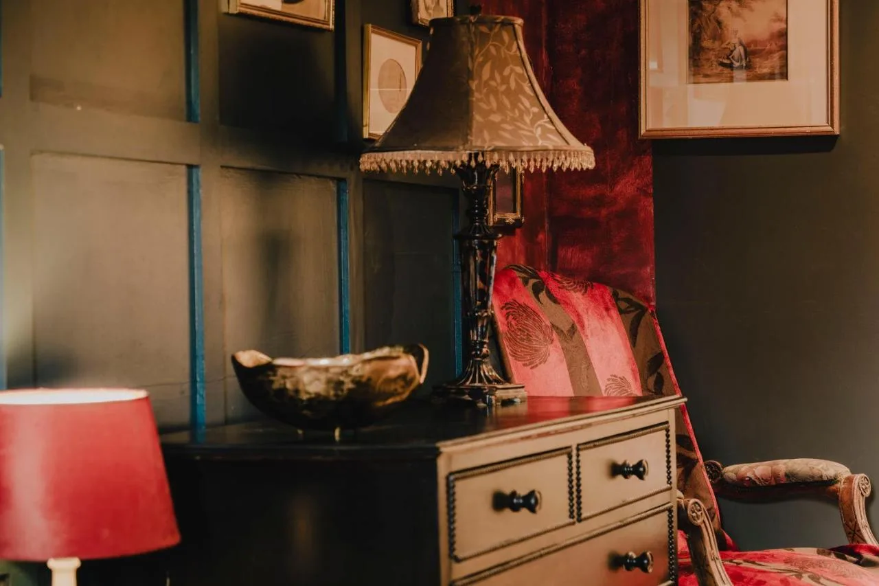 A lamp on top of a dresser next to a chair at The Galaxie in Oxford